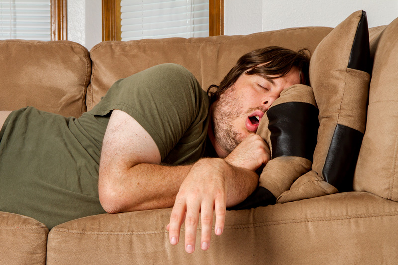 overweight man snoring on couch