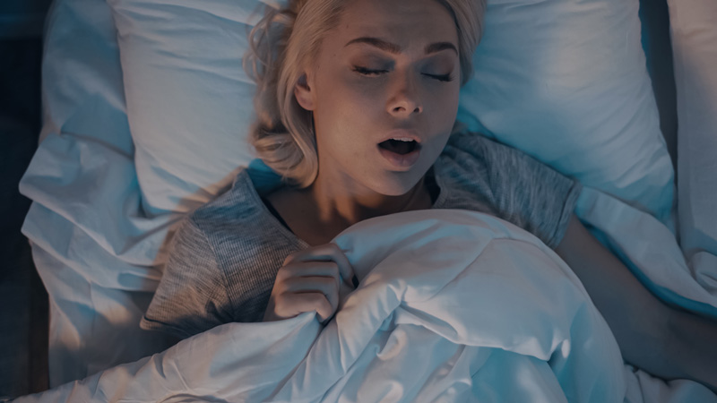 woman with sleep apnea snoring